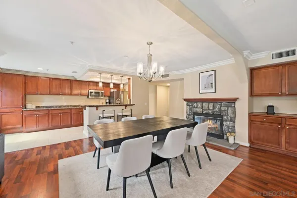 a dining room with furniture a chandelier and wooden floor