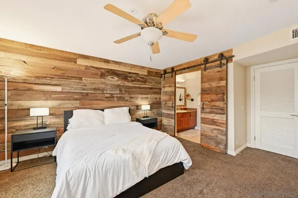 a bedroom with a large bed and a ceiling fan