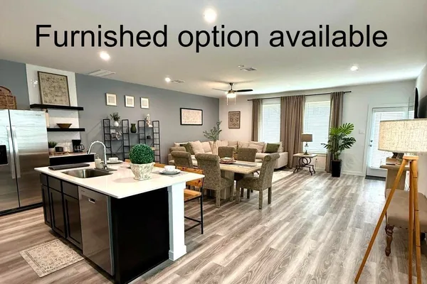 a view of a kitchen with kitchen island a sink a table and chairs in it