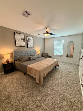 a spacious bedroom with a bed and a chandelier