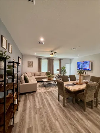 a living room with furniture and a wooden floor