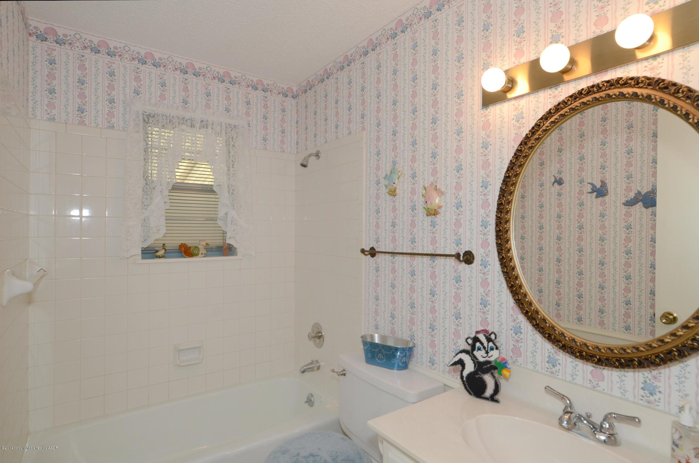 6507 Garwood Road Amarillo, TX 79109 - Photo 15 of 20 a bathroom with a mirror and a sink