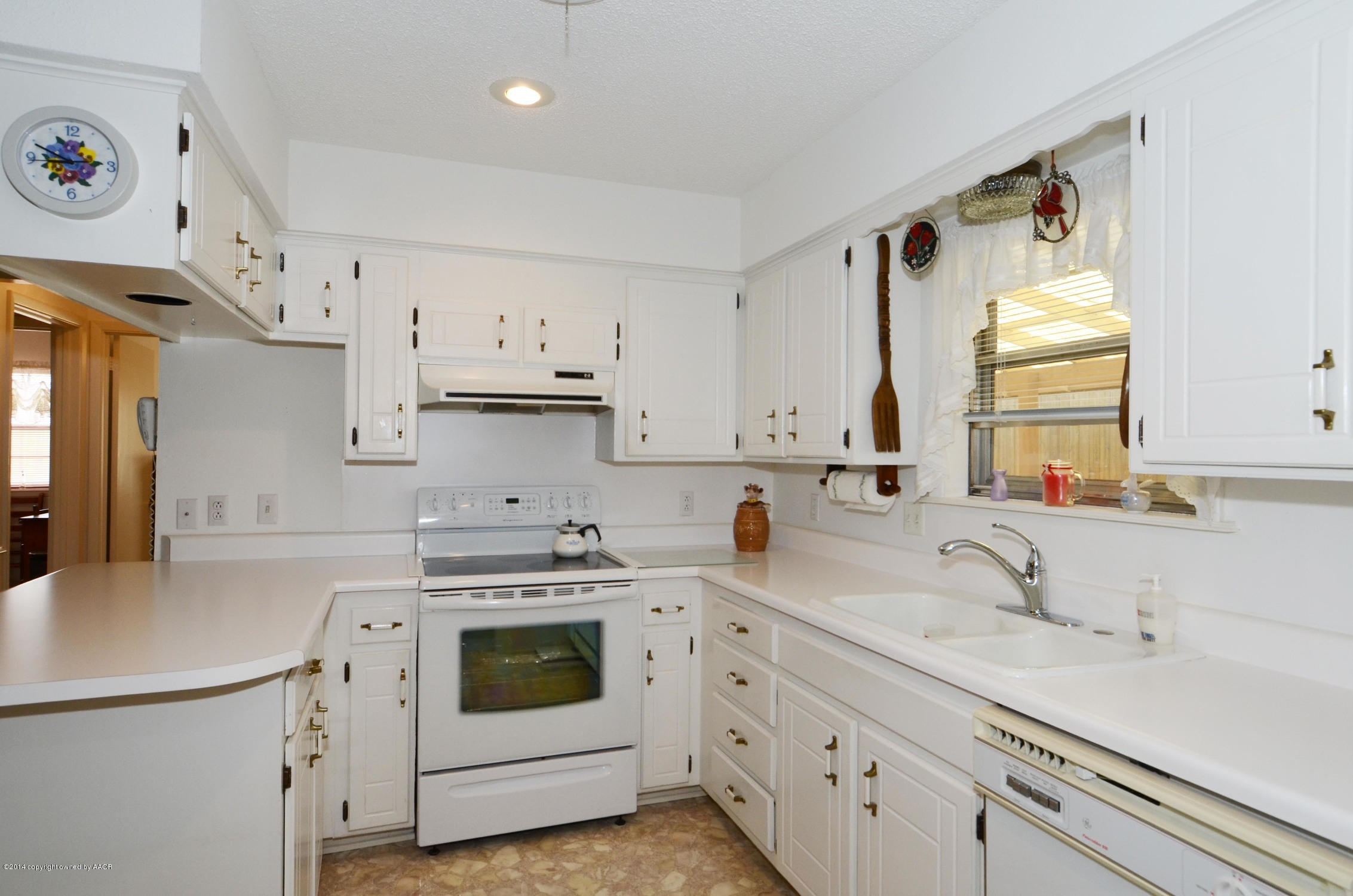 6507 Garwood Road Amarillo, TX 79109 - Photo 10 of 20 a kitchen with cabinets appliances a sink and a window