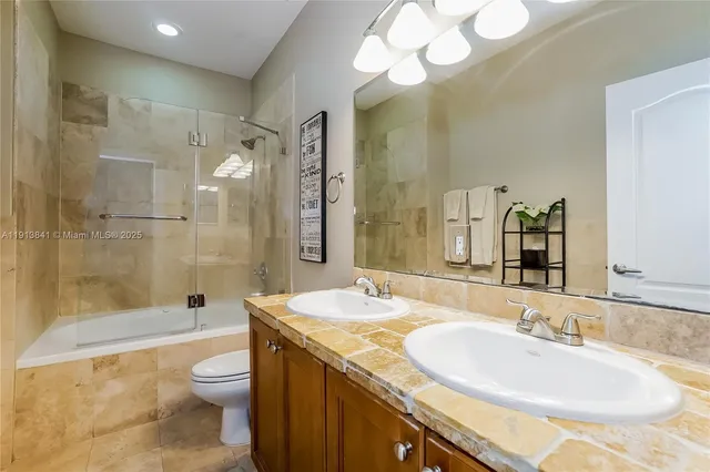 a bathroom with a granite countertop sink mirror toilet and bathtub