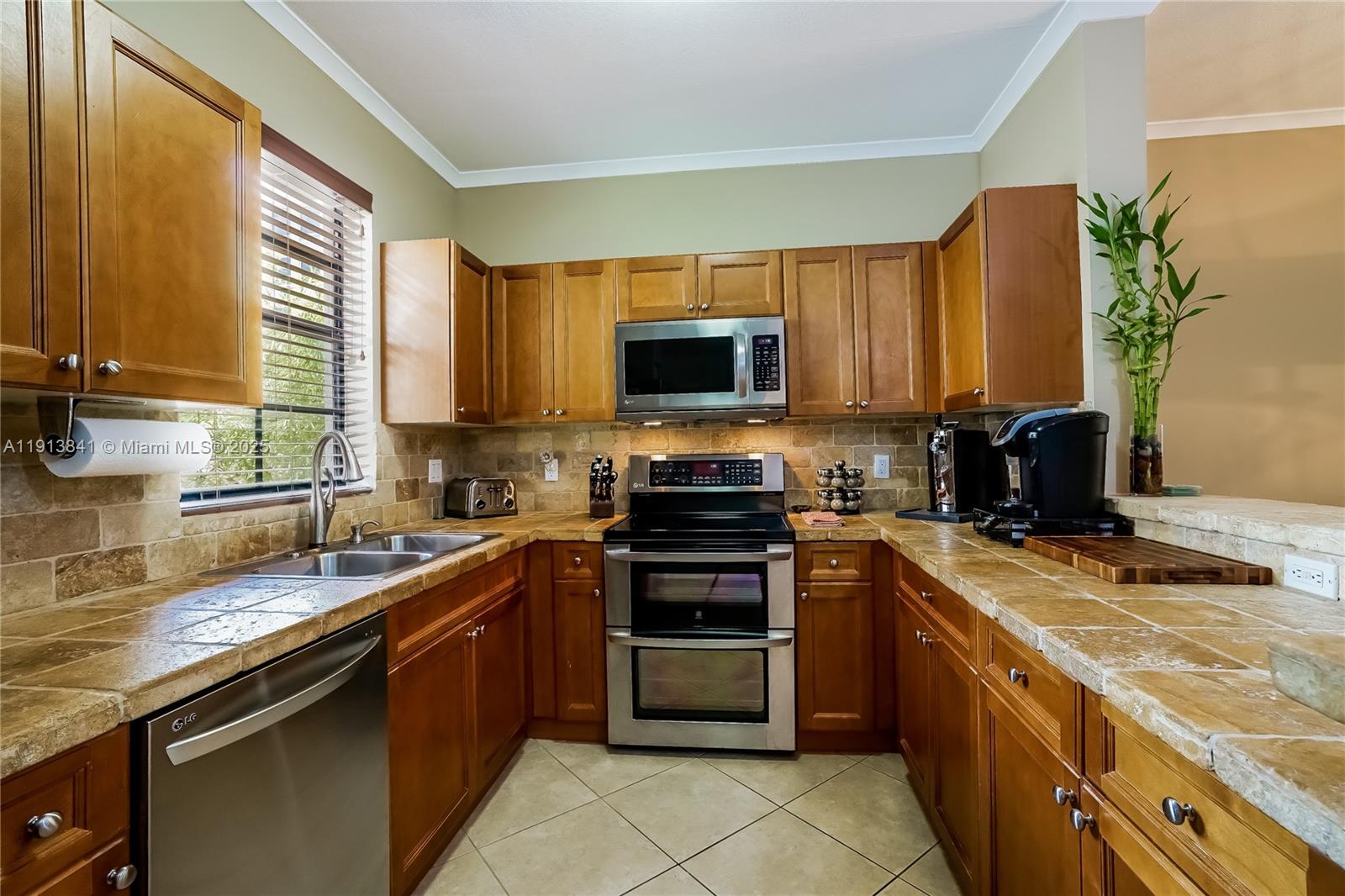 2769 Coconut Avenue, Unit 2769 Coconut Grove, FL 33133 - Photo 6 of 14 a kitchen with stainless steel appliances granite countertop a stove a sink and a microwave