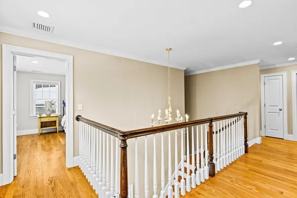 a view of a hallway with wooden floor and dining room