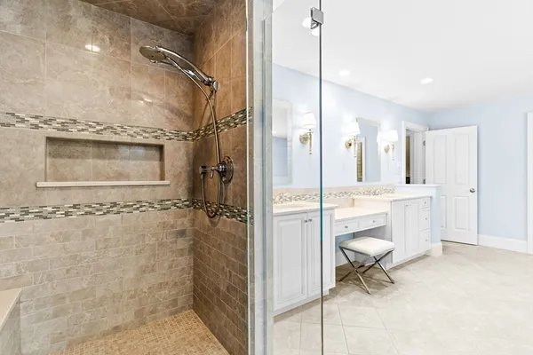 a bathroom with a granite countertop sink a toilet a mirror and shower
