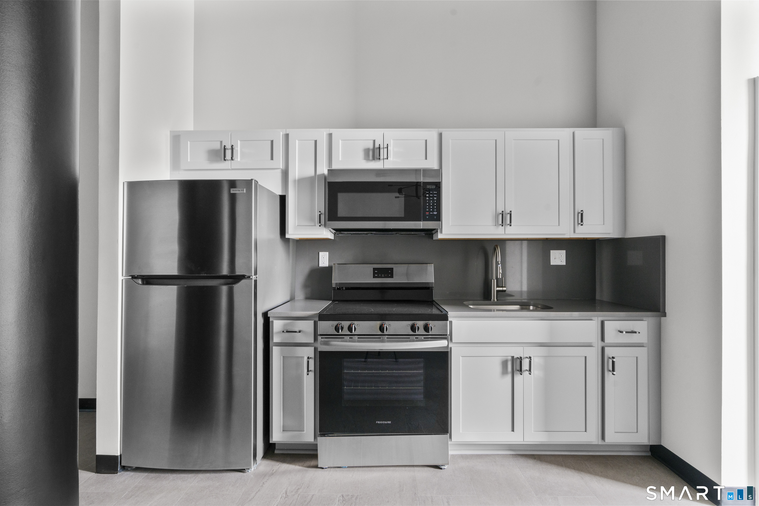 a kitchen with stainless steel appliances a stove a microwave and a refrigerator