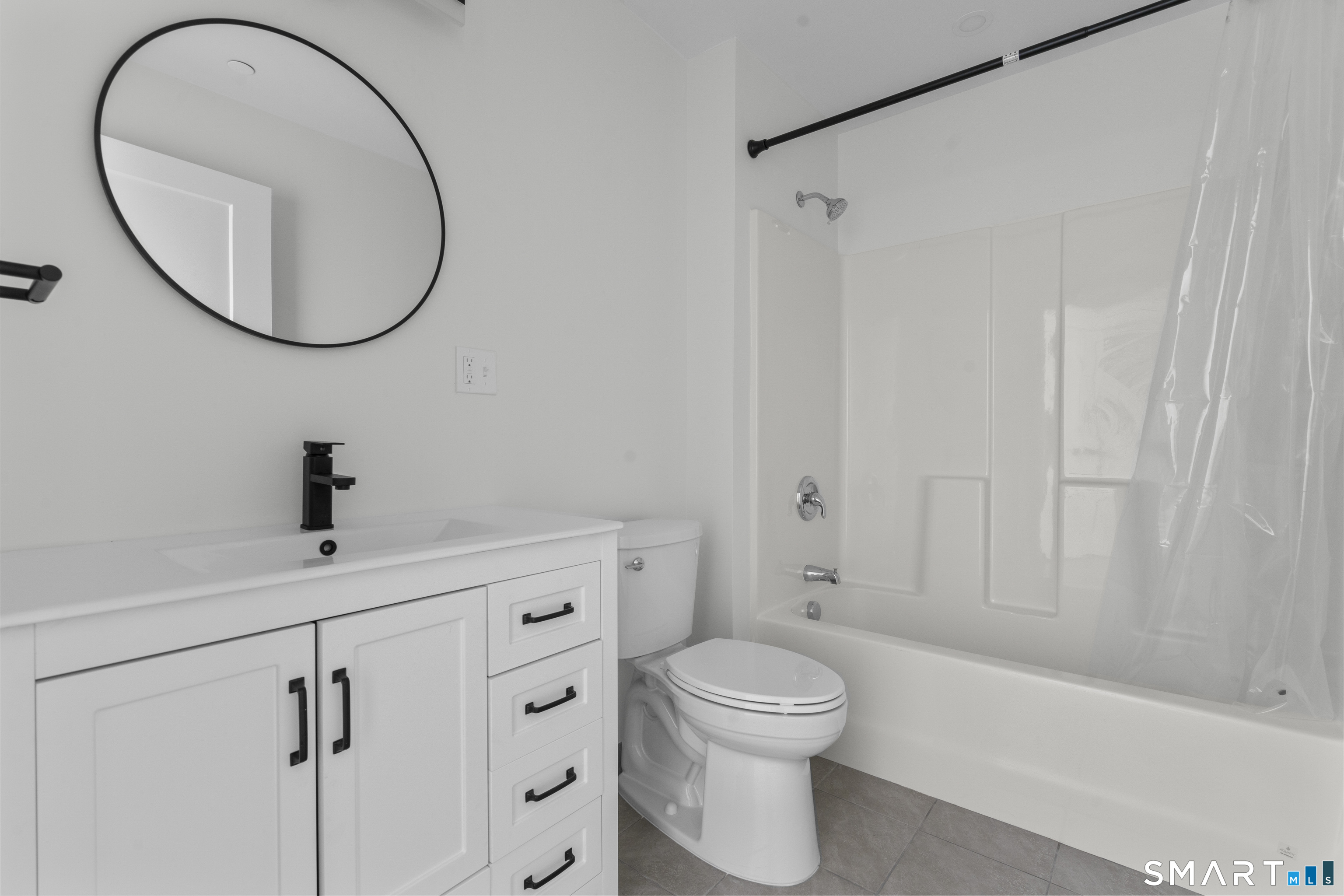 480 Myrtle Street, Unit 404 New Britain, CT 06053 - Photo 7 of 18 a bathroom with a toilet a sink and mirror