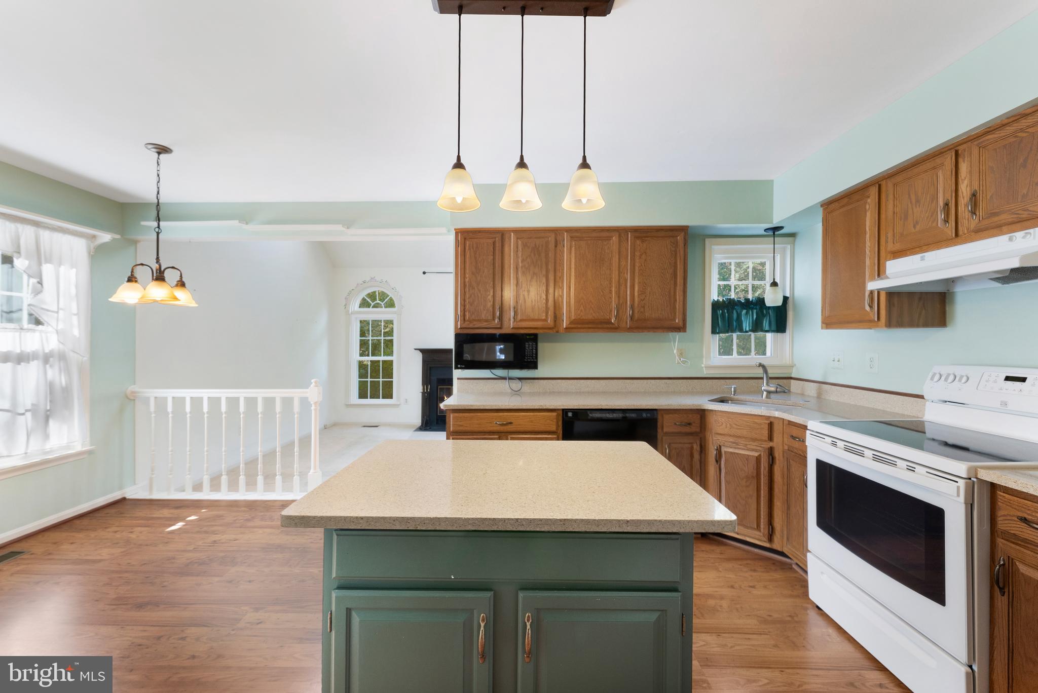 9304 Bellbeck Road Baltimore, MD 21234 - Photo 14 of 37 a kitchen with a stove a sink dishwasher a kitchen island with wooden cabinets and floor
