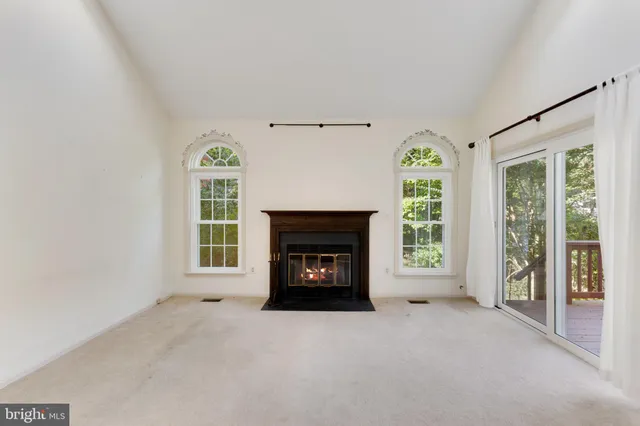 an empty room with a fireplace and windows