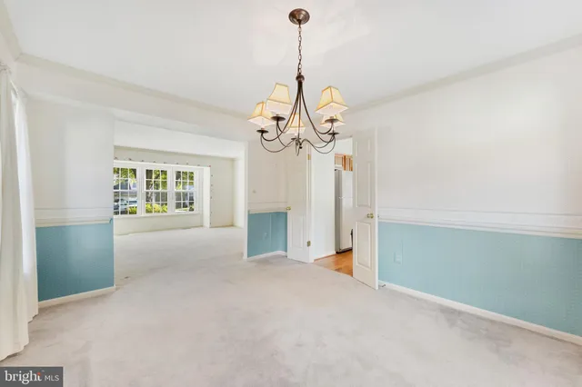 a view of an empty room with a chandelier fan