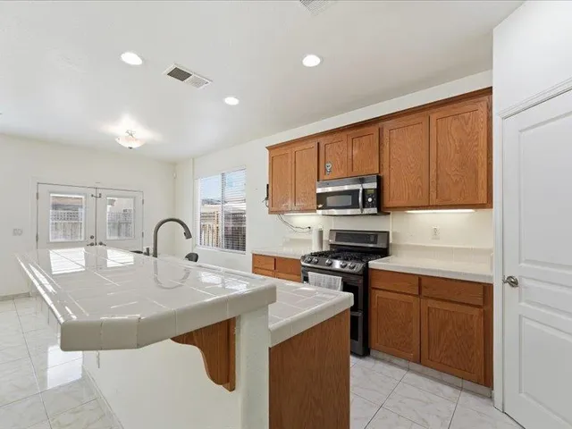 a kitchen with a sink a stove and chairs