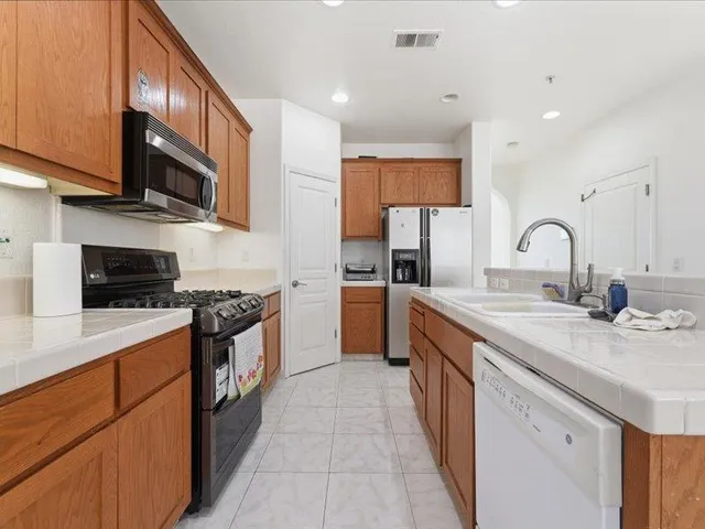 a kitchen with stainless steel appliances granite countertop a sink stove and a refrigerator