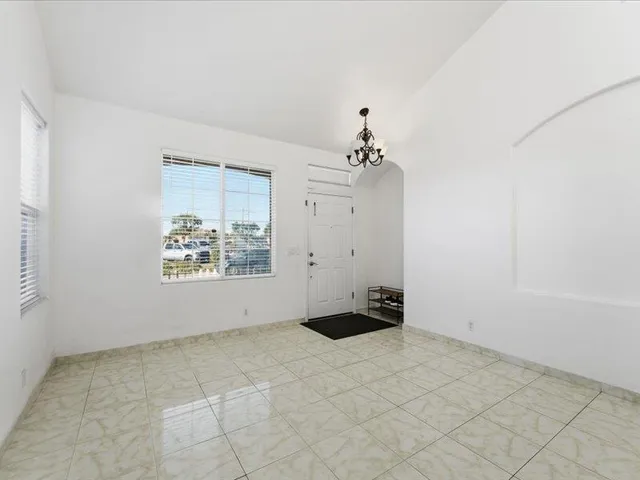 an empty room with kitchen view