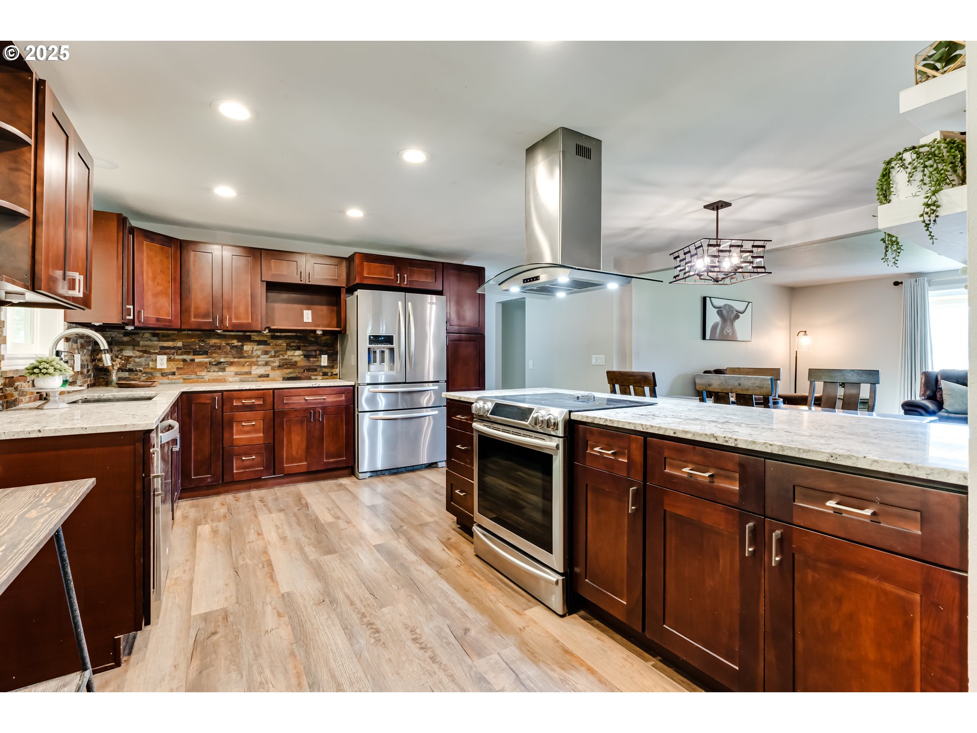 24531 Vaughn Road Veneta, OR 97487 - Photo 13 of 47 a kitchen with stainless steel appliances kitchen island granite countertop a sink counter space cabinets and a large window