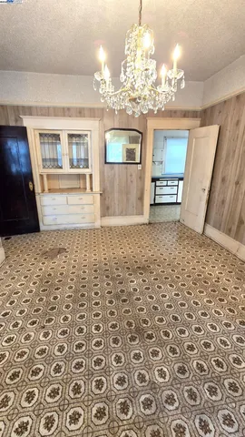 en empty room with wooden floor and chandelier