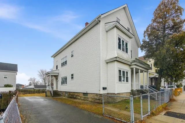 a view of a white house with iron fence