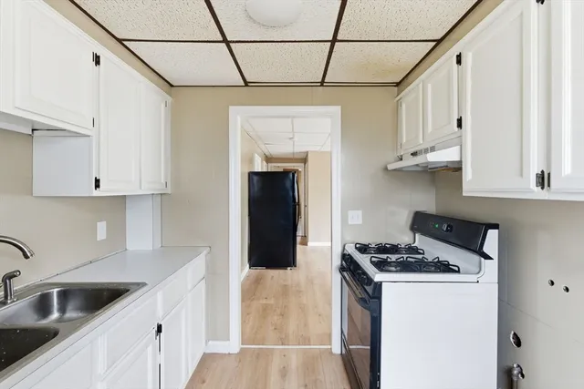 a kitchen with stainless steel appliances granite countertop a sink a stove and refrigerator