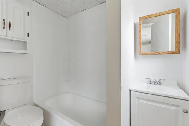 a bathroom with a sink mirror vanity and toilet