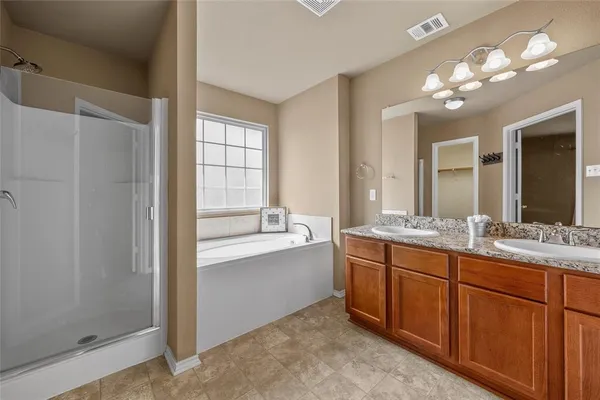 a bathroom with a granite countertop sink a large mirror and a bathtub