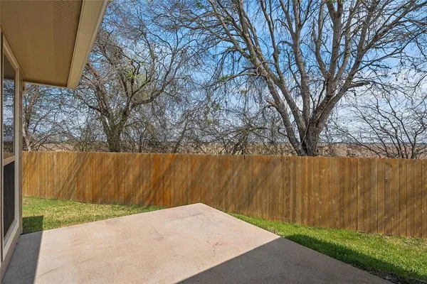 a view of backyard with wooden fence