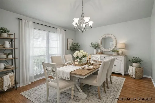 a view of a dining room with furniture a rug and wooden floor
