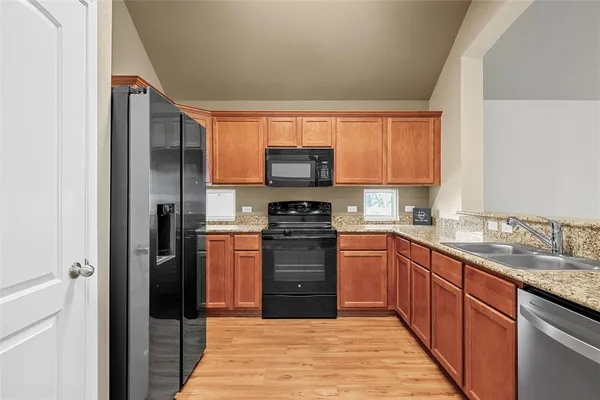 a kitchen with stainless steel appliances granite countertop a stove a sink and a refrigerator
