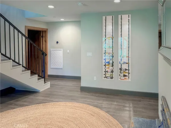 a view of a hallway with wooden floor and a bathroom
