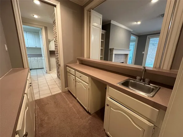a view of an empty room with chandelier fan and fire place