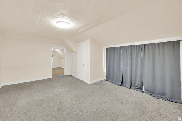 501 Canyon Road Ogden, UT 84404 - Photo 14 of 30 Carpeted room featuring neutral wall tones, a ceiling-mounted light fixture, and a built-in door