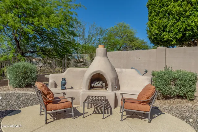 a view of a chairs and table in the back yard of the house