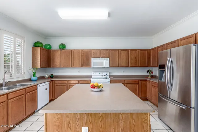 a kitchen with stainless steel appliances granite countertop a refrigerator a sink dishwasher a stove with wooden cabinets and floor