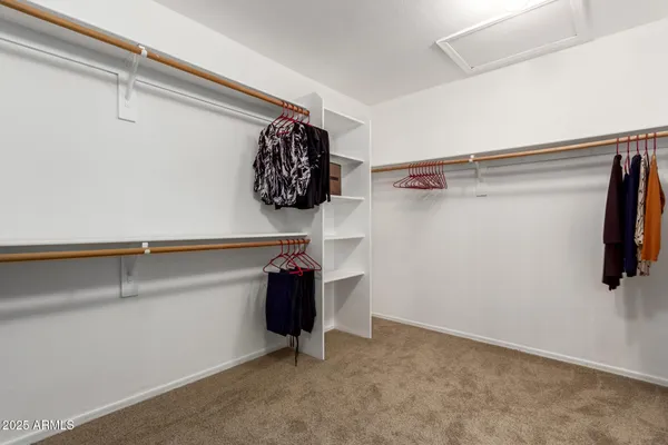 a view of walk in closet with clothes
