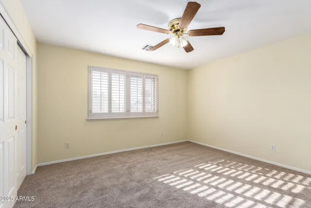 a view of a big room with windows and chandelier fan