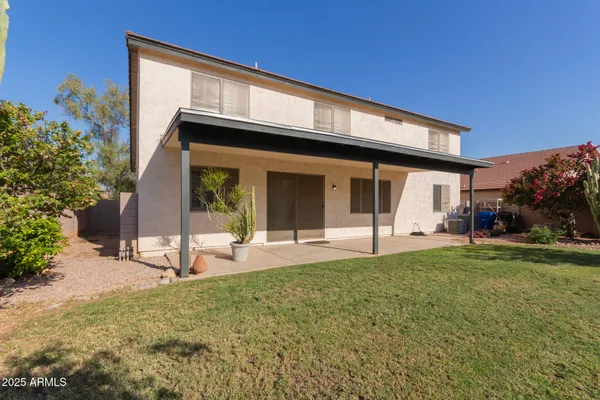 a view of a house with a yard and sitting area