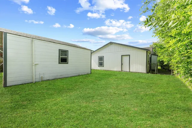 a view of backyard of house with green space