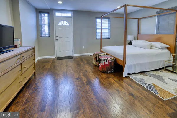 a bedroom with a bed and a flat tv screen on dresser