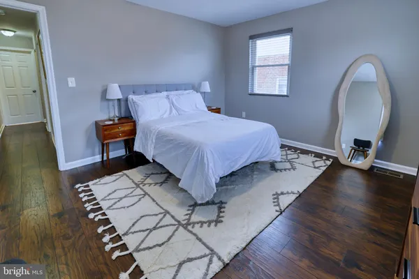 a bedroom with a bed and a potted plant on dresser