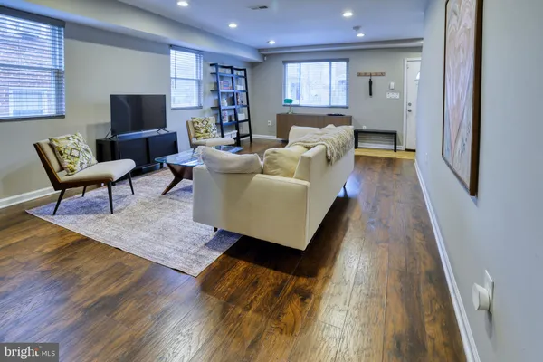 a living room with furniture and a wooden floor