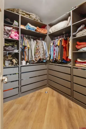 a view of walk in closet with clothes and shoes