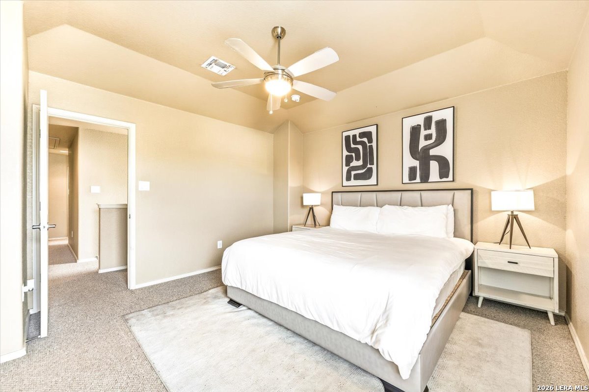3831 Bacall Way Converse, TX 78109 - Photo 19 of 33 a bedroom with a large bed and a chandelier