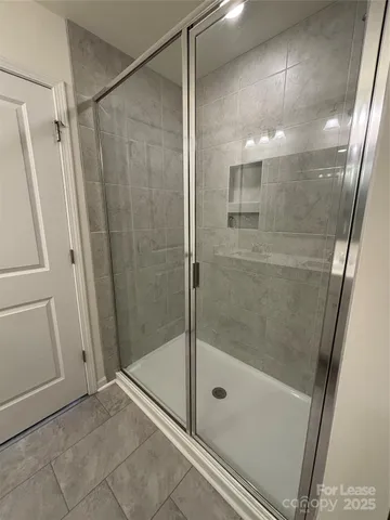 a bathroom with a shower and a glass door shower