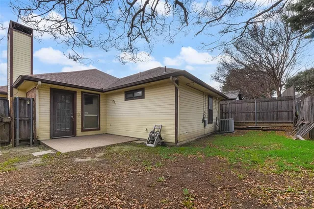 a view of a house with a yard and wooden fence