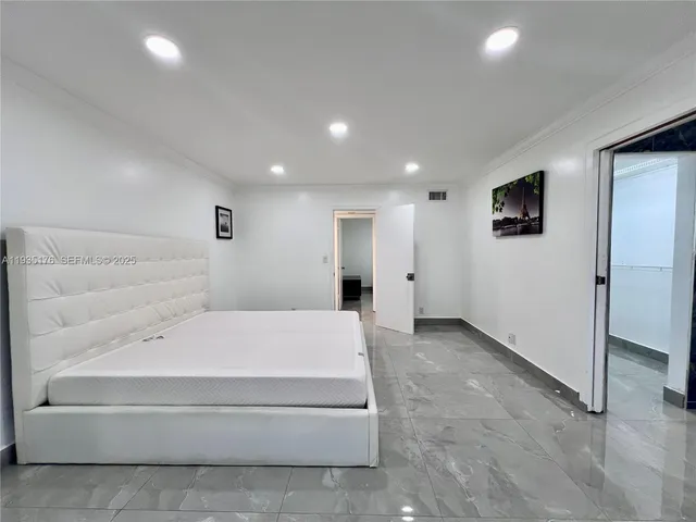 a spacious bedroom with a bed and a couch