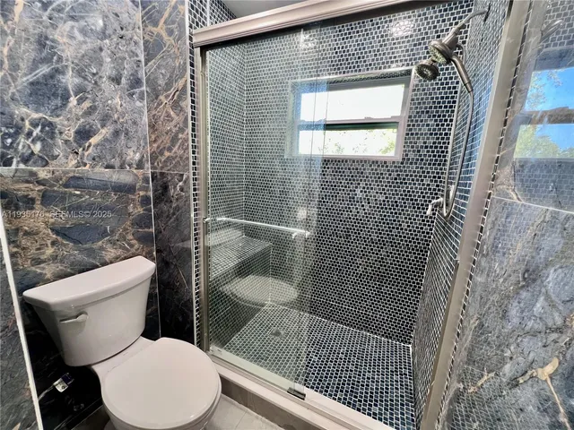 a bathroom with a toilet and a shower
