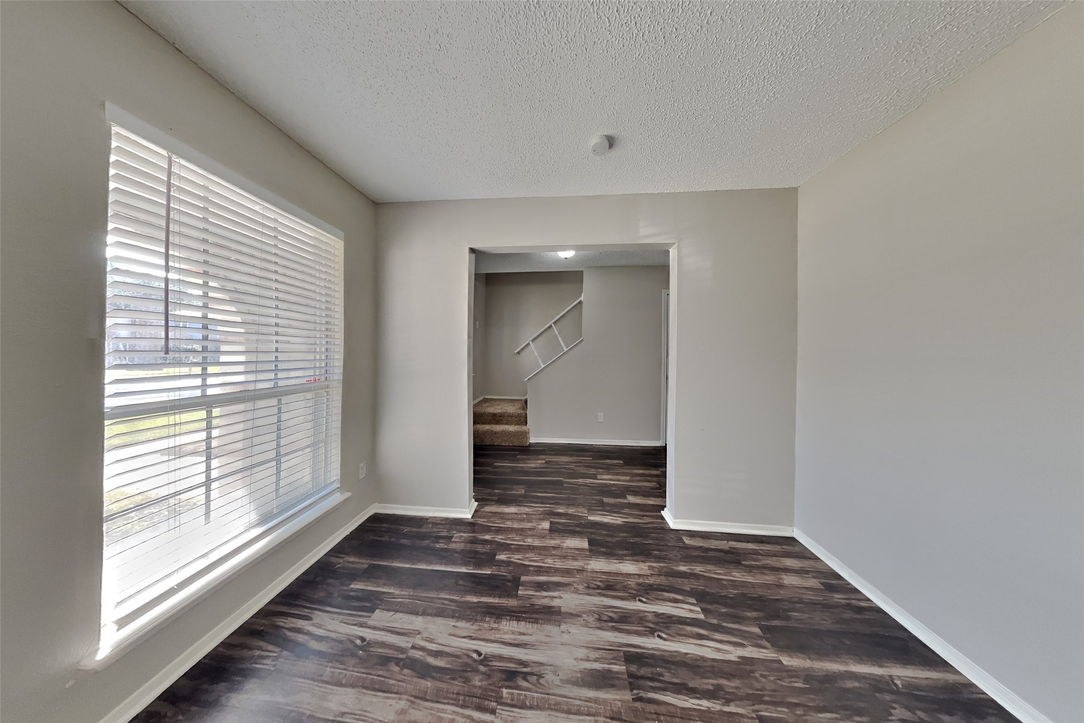 10018 Rippling Fields Drive Houston, TX 77064 - Photo 5 of 21 a view of an empty room with wooden floor and a window