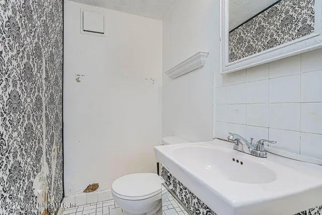 an empty room with windows and chandelier fan