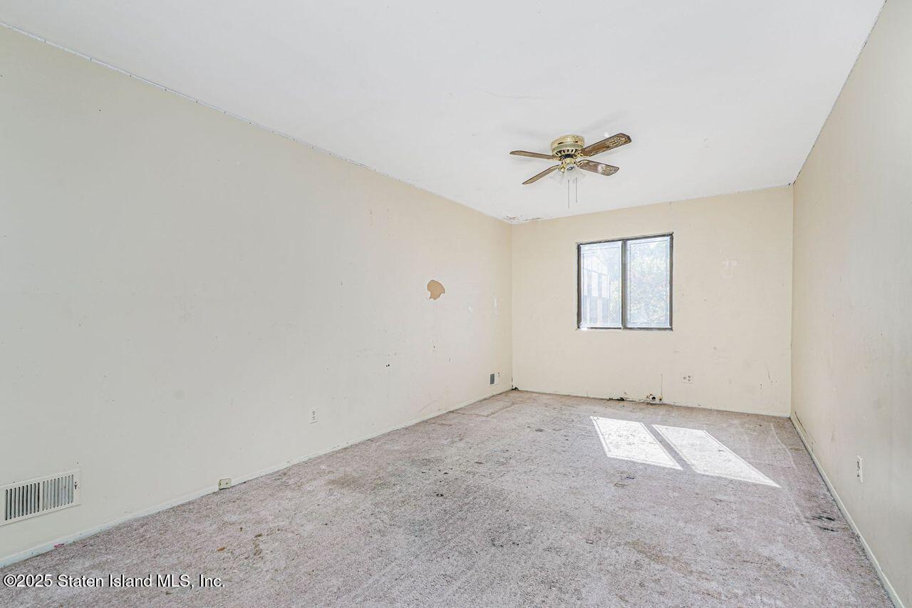 15 Parkview Loop Staten Island, NY 10314 - Photo 20 of 25 an empty room with windows and chandelier fan