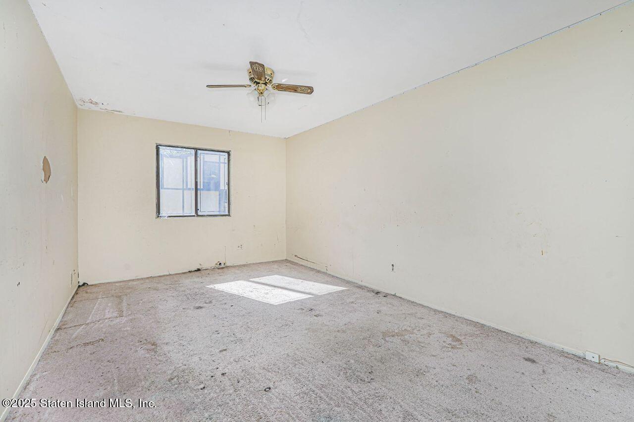 15 Parkview Loop Staten Island, NY 10314 - Photo 21 of 25 an empty room with windows and ceiling fan